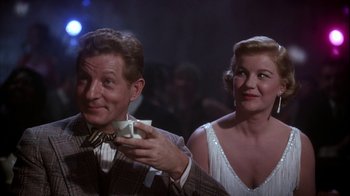 Movie still from “The Five Pennies” (1959), directed by Melville Shavelson – A man and a woman are holding something in their hands; Medium shot, Over the shoulder angle