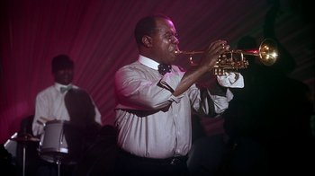 Movie still from “The Five Pennies” (1959), directed by Melville Shavelson – A man playing a trumpet in front of a group of people; Medium shot, Low angle