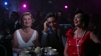 Movie still from “The Five Pennies” (1959), directed by Melville Shavelson – A group of people sitting at a table with cups and saucers on it; Medium shot, Low angle