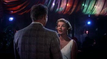 Movie still from “The Five Pennies” (1959), directed by Melville Shavelson – An older man and a younger woman are talking in front of a crowd; Medium shot, Over the shoulder angle