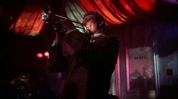 Movie still from “The Five Pennies” (1959), directed by Melville Shavelson – A man in a suit playing a trumpet; Medium shot, Low angle