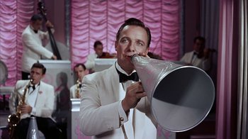 Movie still from “The Five Pennies” (1959), directed by Melville Shavelson – A man in a white suit is holding a megaphone; Medium shot, Low angle