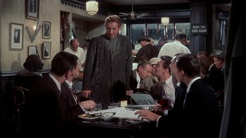 Movie still from “The Five Pennies” (1959), directed by Melville Shavelson – A group of people sitting around a table; Medium shot, Over the shoulder angle