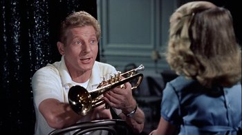Movie still from “The Five Pennies” (1959), directed by Melville Shavelson – A man sitting in front of a woman holding a trumpet; Close Up shot, Low angle
