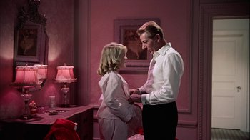 Movie still from “The Five Pennies” (1959), directed by Melville Shavelson – A man and a woman standing next to each other in a room; Medium shot, High angle