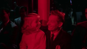 Movie still from “The Five Pennies” (1959), directed by Melville Shavelson – A man and a woman smiling at each other in front of a red light; Close Up shot, High angle