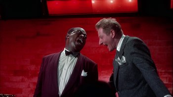 Movie still from “The Five Pennies” (1959), directed by Melville Shavelson – Two men in suits laugh while standing next to each other; Medium shot, High angle