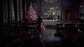 Movie still from “The Five Pennies” (1959), directed by Melville Shavelson – A little girl in a pink dress standing in front of a pink christmas tree; Wide shot, High angle