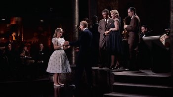 Movie still from “The Five Pennies” (1959), directed by Melville Shavelson – A group of people standing on steps in front of a building; Wide shot, High angle