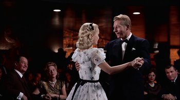 Movie still from “The Five Pennies” (1959), directed by Melville Shavelson – A man and a woman are dancing in front of other people; Medium shot, Low angle