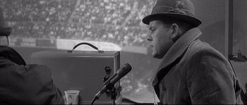 Movie still from “The Fortune Cookie” (1966), directed by Billy Wilder – A man with a hat and a microphone in front of him; Close Up shot, High angle