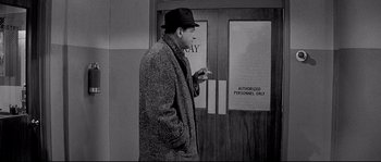 Movie still from “The Fortune Cookie” (1966), directed by Billy Wilder – A black and white photo of a man smoking a cigarette; Medium shot, High angle