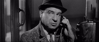 Movie still from “The Fortune Cookie” (1966), directed by Billy Wilder – An old photo of a man talking on a phone; Close Up shot, High angle