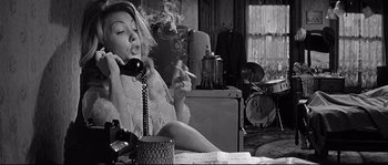 Movie still from “The Fortune Cookie” (1966), directed by Billy Wilder – A woman smoking a cigarette while talking on the phone; Medium shot, High angle