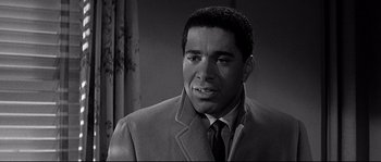 Movie still from “The Fortune Cookie” (1966), directed by Billy Wilder – A black and white photo of a man in a suit and tie; Close Up shot, Over the shoulder angle