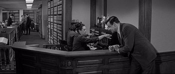 Movie still from “The Fortune Cookie” (1966), directed by Billy Wilder – A man and a woman are sitting at a counter; Medium shot, Low angle