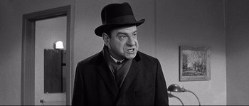 Movie still from “The Fortune Cookie” (1966), directed by Billy Wilder – A man wearing a suit and a hat; Close Up shot, Over the shoulder angle