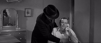 Movie still from “The Fortune Cookie” (1966), directed by Billy Wilder – An old photo of a man talking on the phone with another man; Medium shot, Over the shoulder angle