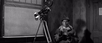 Movie still from “The Fortune Cookie” (1966), directed by Billy Wilder – A black and white photo of a man holding a camera; Medium shot, High angle