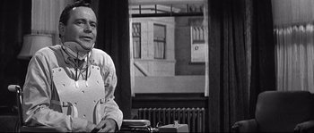 Movie still from “The Fortune Cookie” (1966), directed by Billy Wilder – A man standing in front of an old fashioned typewriter; Medium shot, Low angle