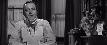 Movie still from “The Fortune Cookie” (1966), directed by Billy Wilder – A man wearing a neck brace in a room; Close Up shot, Over the shoulder angle