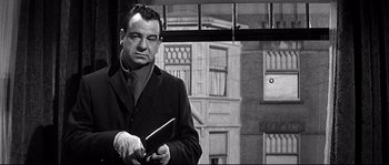 Movie still from “The Fortune Cookie” (1966), directed by Billy Wilder – A man holding a butcher knife in front of a building; Close Up shot, Over the shoulder angle