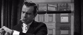 Movie still from “The Fortune Cookie” (1966), directed by Billy Wilder – Black and white photograph of a man in a suit and tie; Close Up shot, Over the shoulder angle