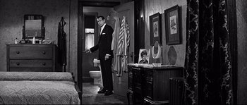 Movie still from “The Fortune Cookie” (1966), directed by Billy Wilder – A black and white photo of a man in a suit and tie; Wide shot, Over the shoulder angle
