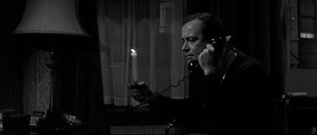 Movie still from “The Fortune Cookie” (1966), directed by Billy Wilder – A black and white photo of a man holding a candle; Close Up shot, High angle