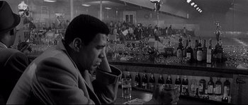 Movie still from “The Fortune Cookie” (1966), directed by Billy Wilder – A black and white photo of a man sitting at a bar; Medium shot, Low angle