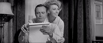 Movie still from “The Fortune Cookie” (1966), directed by Billy Wilder – An older man and a younger woman looking at a paper; Medium shot, Low angle