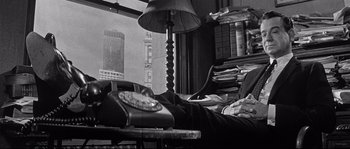 Movie still from “The Fortune Cookie” (1966), directed by Billy Wilder – An old phone is sitting on a table; Medium shot, High angle