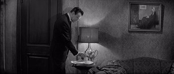 Movie still from “The Fortune Cookie” (1966), directed by Billy Wilder – A black and white photo of a man cutting a cake; Medium shot, High angle