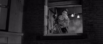 Movie still from “The Fortune Cookie” (1966), directed by Billy Wilder – An old photo of a man looking through a window; Medium shot, Low angle