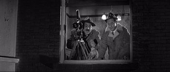 Movie still from “The Fortune Cookie” (1966), directed by Billy Wilder – Two men are standing in front of a camera; Medium shot, Low angle