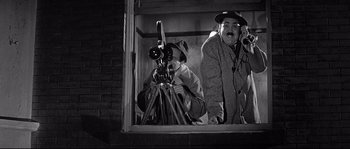 Movie still from “The Fortune Cookie” (1966), directed by Billy Wilder – Two men are looking out of a window; Medium shot, Low angle