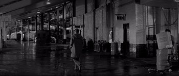 Movie still from “The Fortune Cookie” (1966), directed by Billy Wilder – A person walking in the rain in a building; Wide shot, Low angle