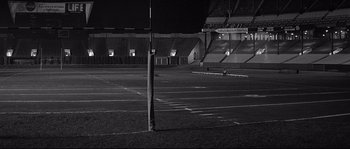 Movie still from “The Fortune Cookie” (1966), directed by Billy Wilder – An empty football field at night with no fans; Extreme Wide shot, High angle