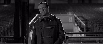 Movie still from “The Fortune Cookie” (1966), directed by Billy Wilder – A black and white photo of a man wearing a coat; Medium shot, Low angle