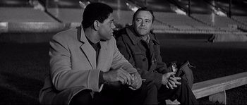 Movie still from “The Fortune Cookie” (1966), directed by Billy Wilder – A black and white photo of two men sitting next to each other; Medium shot, Low angle