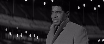 Movie still from “The Fortune Cookie” (1966), directed by Billy Wilder – Black and white photograph of a man wearing a coat; Medium shot, Low angle