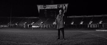 Movie still from “The Fortune Cookie” (1966), directed by Billy Wilder – An older man holding a football on a field; Wide shot, Low angle