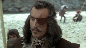 Movie still from “The Four Musketeers: Milady's Revenge” (1974), directed by Richard Lester – A person with long grey hair; Close Up shot, Over the shoulder angle