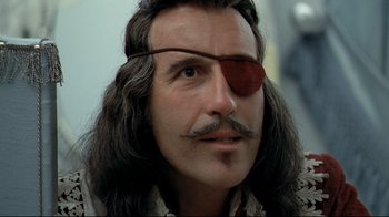 Movie still from “The Four Musketeers: Milady's Revenge” (1974), directed by Richard Lester – A person with long hair wearing a pirate eye patch; Close Up shot, Over the shoulder angle