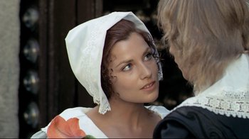 Movie still from “The Four Musketeers: Milady's Revenge” (1974), directed by Richard Lester – A woman wearing a white hat and a white dress; Close Up shot, Over the shoulder angle