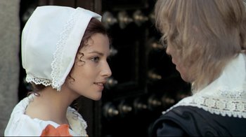 Movie still from “The Four Musketeers: Milady's Revenge” (1974), directed by Richard Lester – A young woman wearing a white dress and a white hat; Close Up shot, Over the shoulder angle