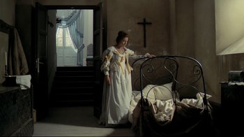 Movie still from “The Four Musketeers: Milady's Revenge” (1974), directed by Richard Lester – A woman dressed in a medieval dress standing in front of a bed; Wide shot, High angle