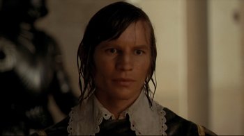 Movie still from “The Four Musketeers: Milady's Revenge” (1974), directed by Richard Lester – A man with long black hair wearing a white collar; Close Up shot, High angle