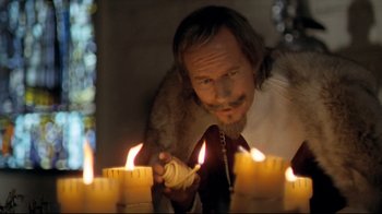 Movie still from “The Four Musketeers: Milady's Revenge” (1974), directed by Richard Lester – A man lighting candles in a dark room; Close Up shot, Low angle
