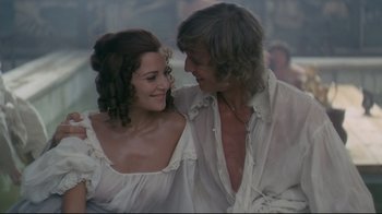 Movie still from “The Four Musketeers: Milady's Revenge” (1974), directed by Richard Lester – A man and a woman are smiling and embracing; Medium shot, High angle